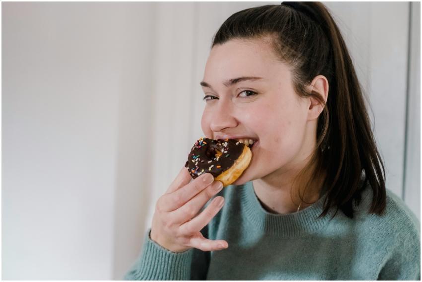 Delighted young female biting delicious sweet choc