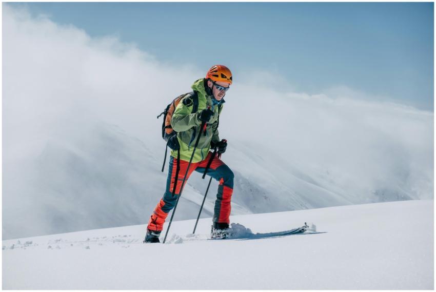 A skier trekking uphill on a snowy mountain in bri
