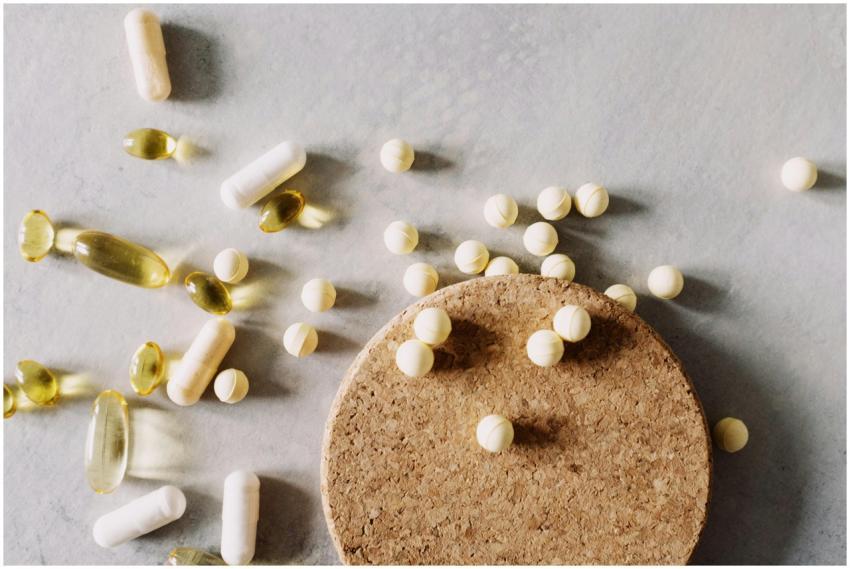 A mix of various capsules and pills scattered on a