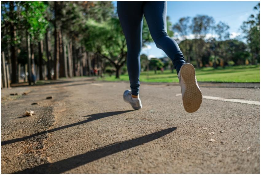 A woman running outdoors on a sunny day along a sc