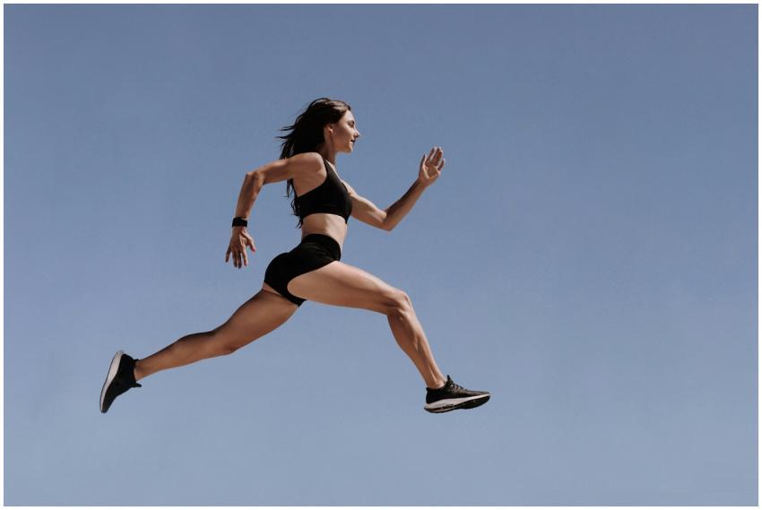 Athletic woman in motion leaping across the sky de