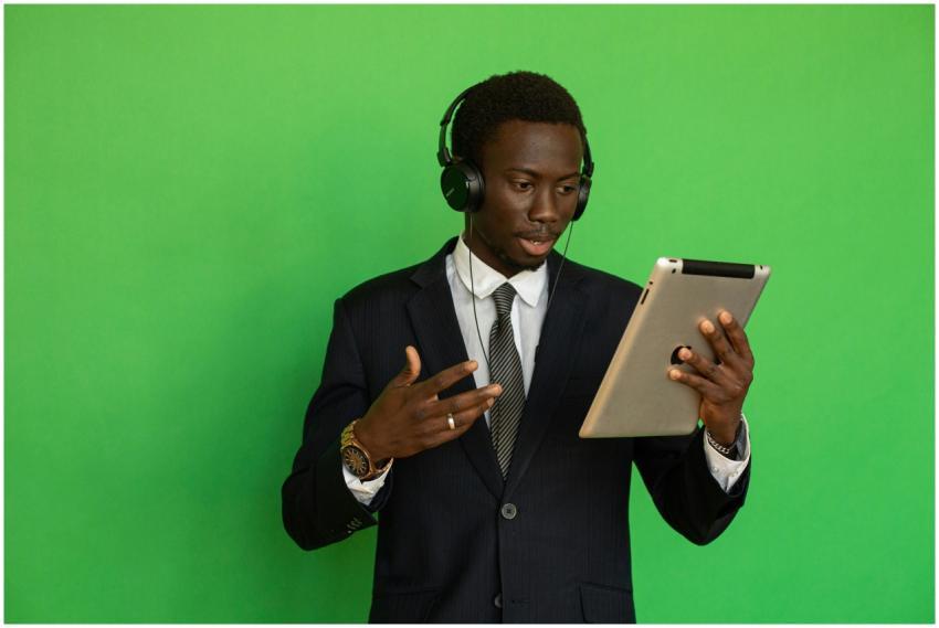 Young black man in formal attire using a tablet wi