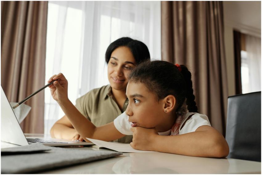 Mother and daughter engaged in online learning at