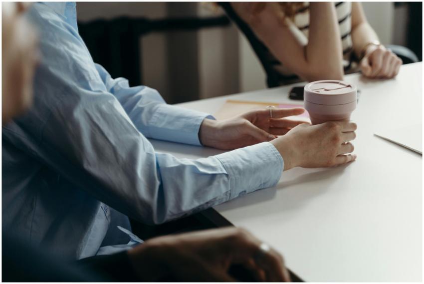 Close-up of people holding a coffee cup during a c
