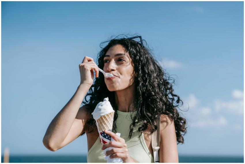 A woman savors an ice cream cone outdoors against