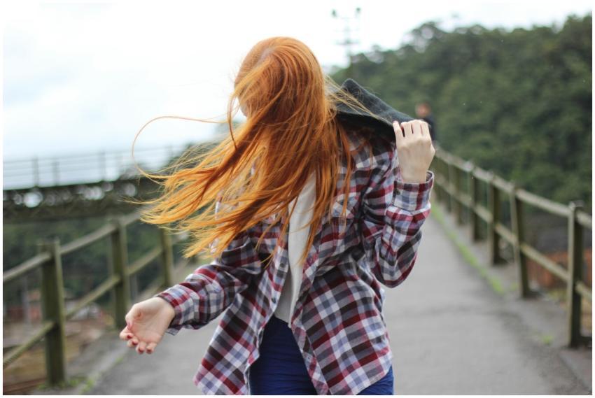 Portrait of a redhead woman outdoors with hair blo