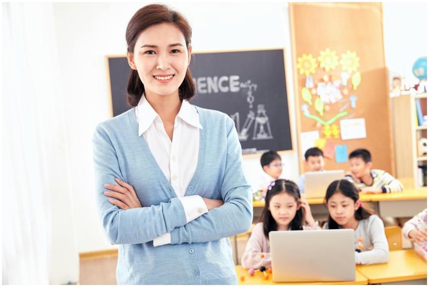Smiling teacher posing in a classroom with engaged