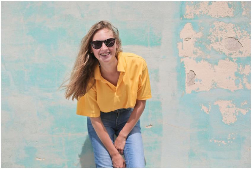 Casual young woman smiling in sunglasses, posing a
