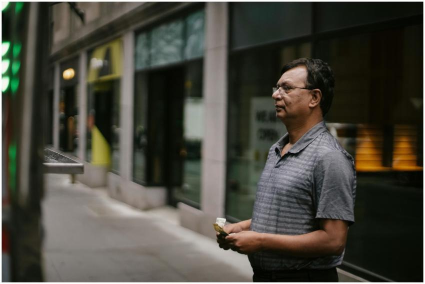 Man holding cash, standing at a food truck on a ci