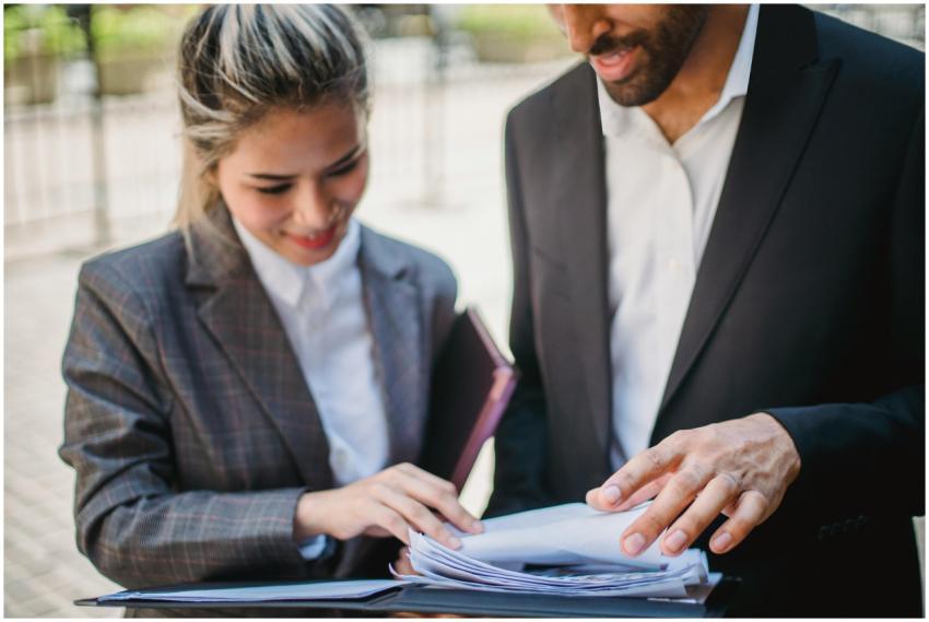 Two business professionals in formal attire review