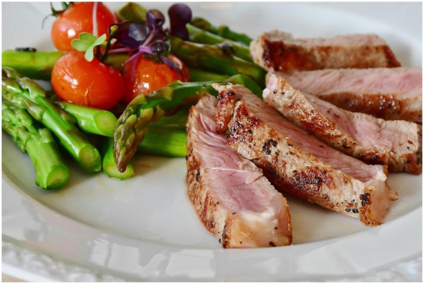 Close-up of grilled steak slices with asparagus an
