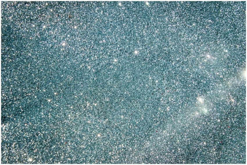 Silver glitter background with bright sparkles and