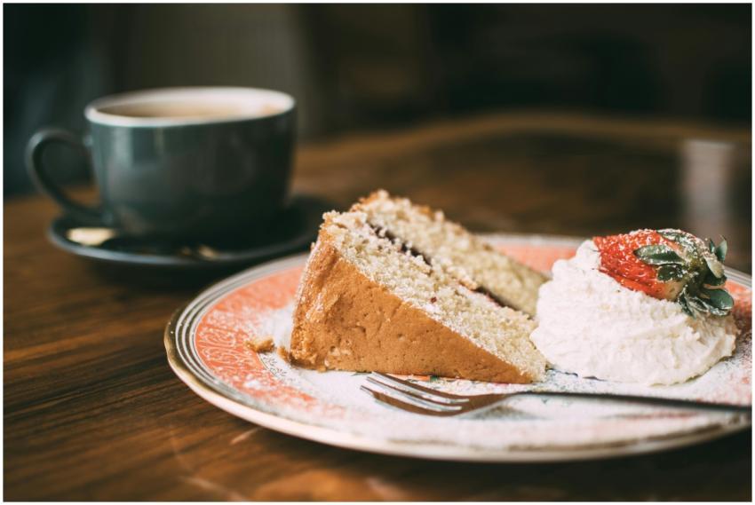 A slice of sponge cake with cream and strawberry,