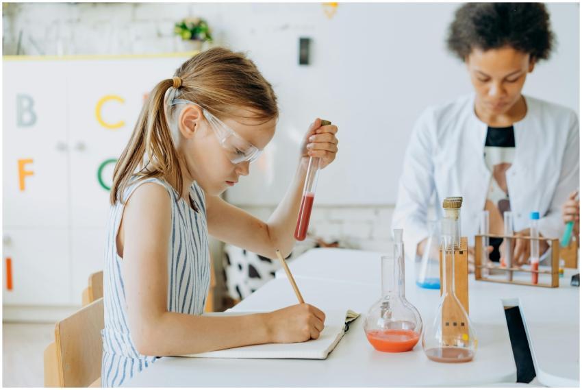 Child conducting science experiment with teacher i