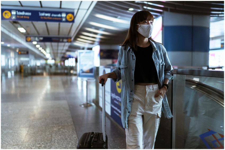 Woman wearing mask and denim jacket in airport ter