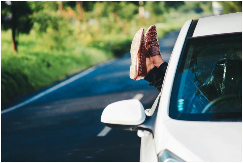 Man relaxing in car, scenic road trip in summer. F