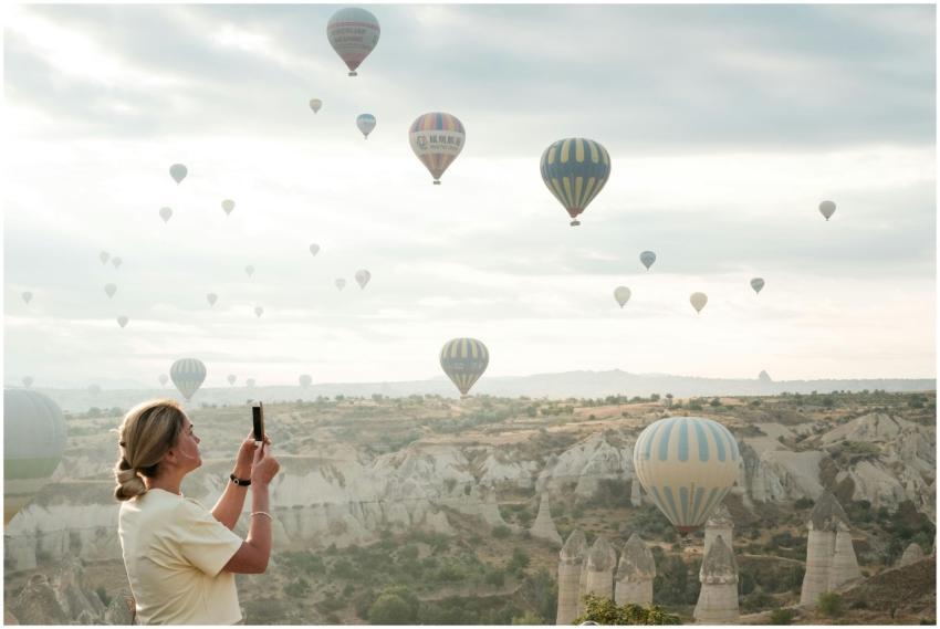 Woman photographing hot air balloons in Cappadocia