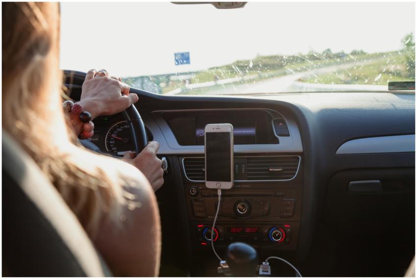 View from behind a woman driving a car on a sunny