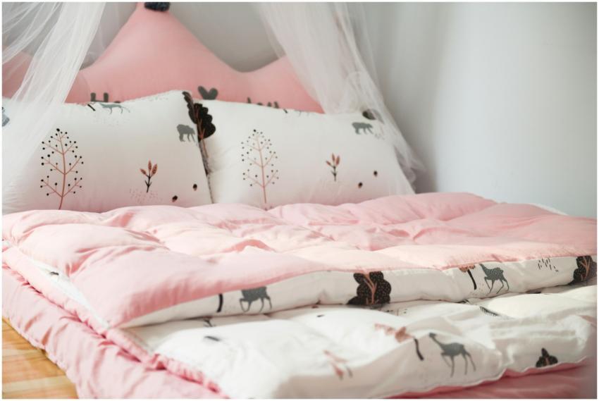 A cozy bedroom with pink bedding and animal patter