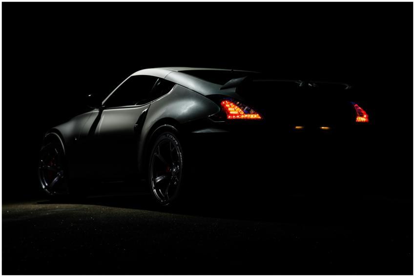 A dramatic shot of a Nissan 370Z sports car illumi