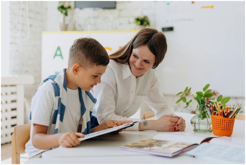 A teacher helping a young boy learn using a tablet