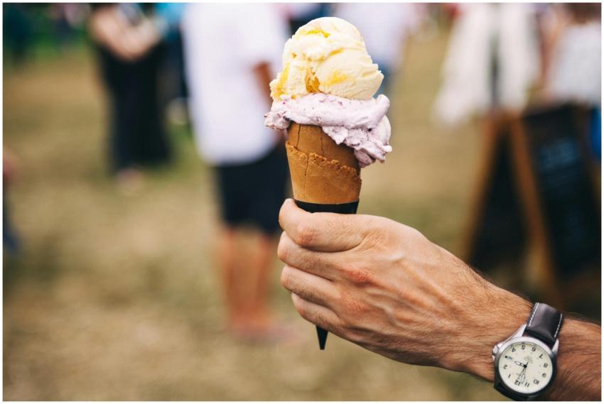 Hand holding an ice cream cone with multiple flavo