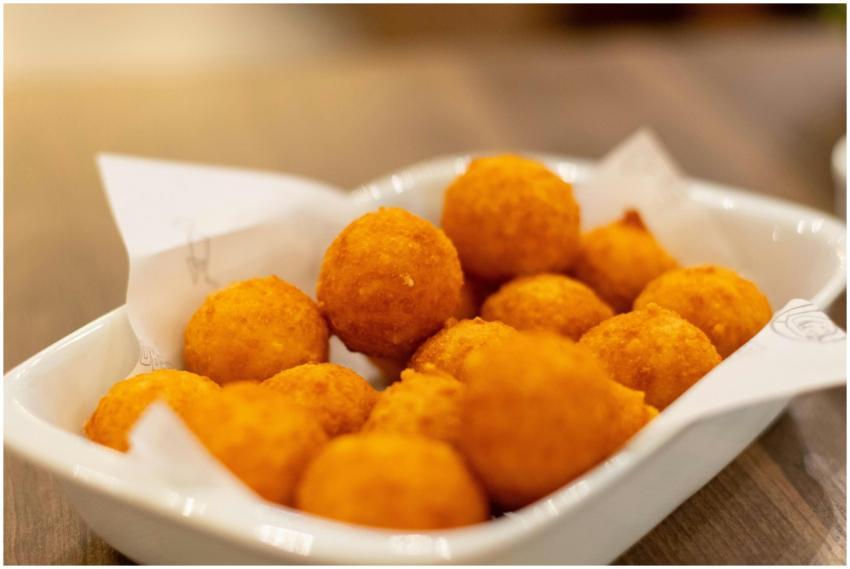 Appetizing golden cheese balls served on a white p