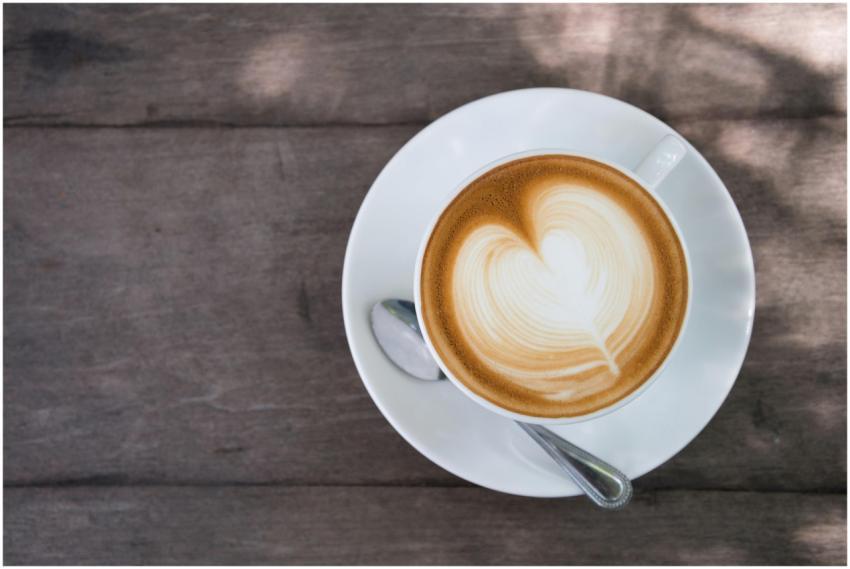 A cup of cappuccino with heart-shaped latte art si