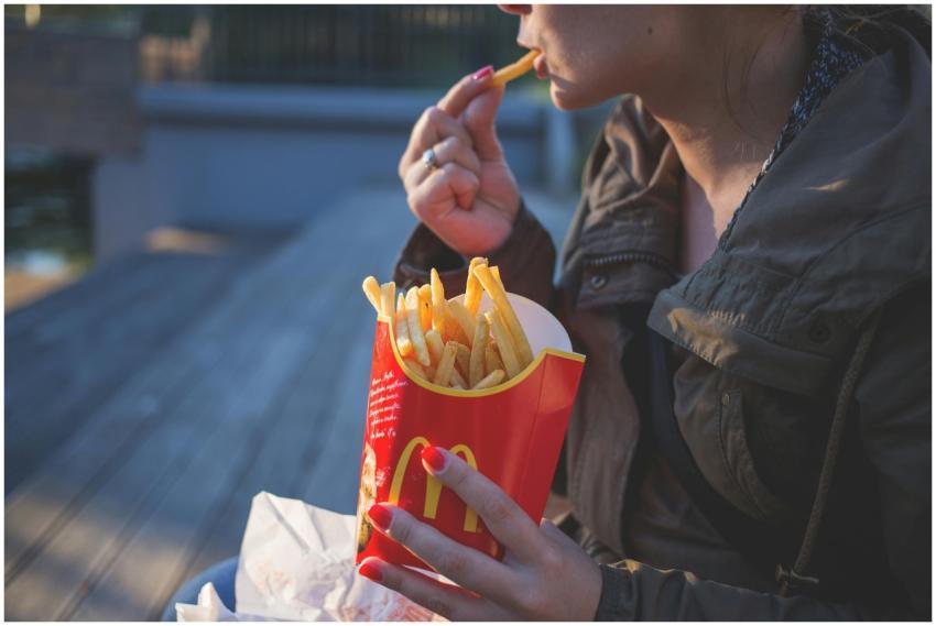 Close-up of a woman enjoying French fries outdoors