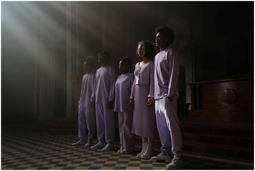 A group of five adults in a church choir singing u
