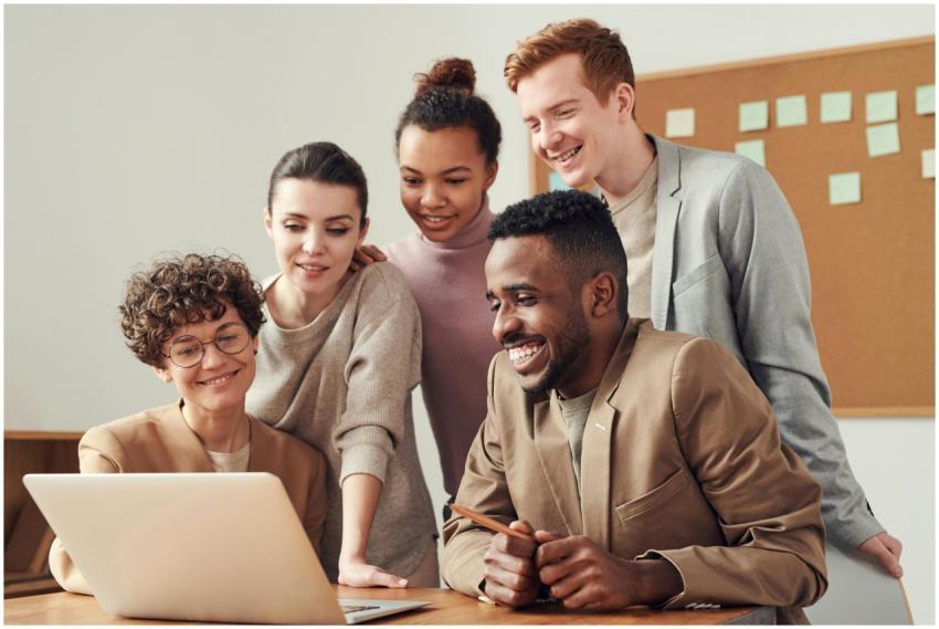 A group of diverse young professionals happily col