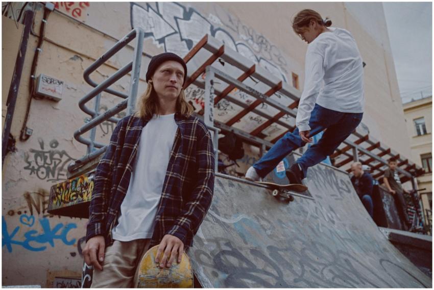 Two skateboarders in a graffiti-covered skate park