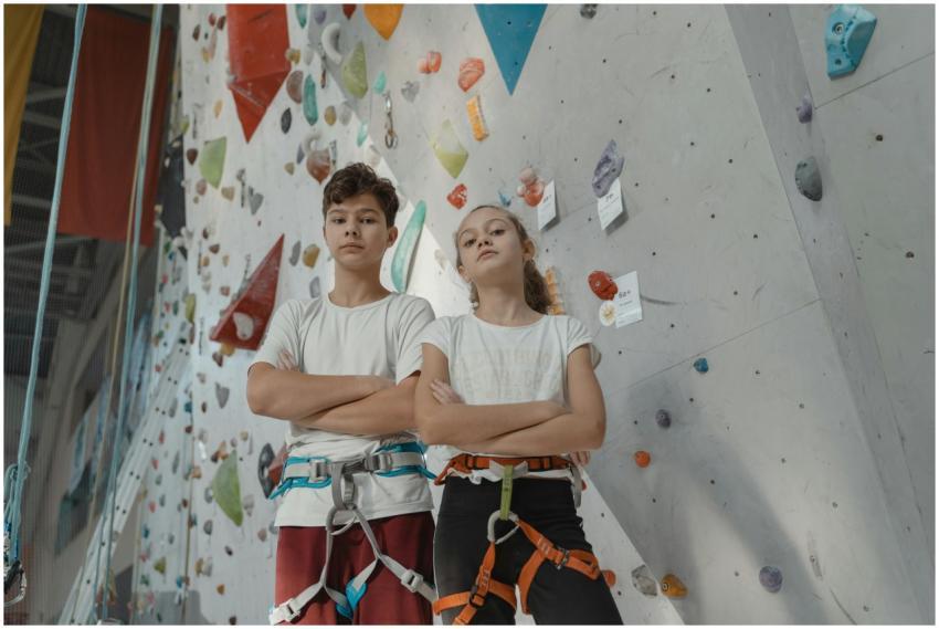 Two young climbers confidently pose in front of a