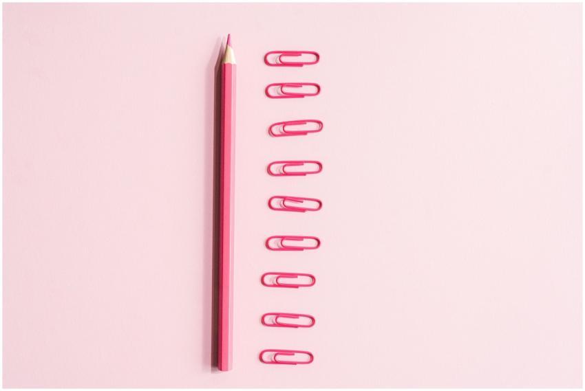 A top view of a pink pencil and pink paper clips a