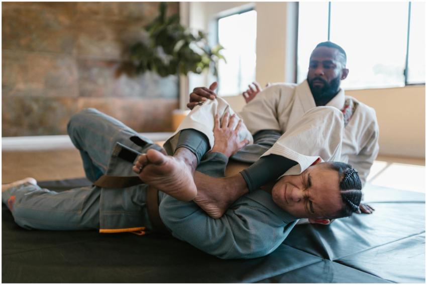 Two men practicing martial arts sparring indoors w