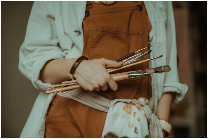 Close-up of a woman holding paintbrushes in an art