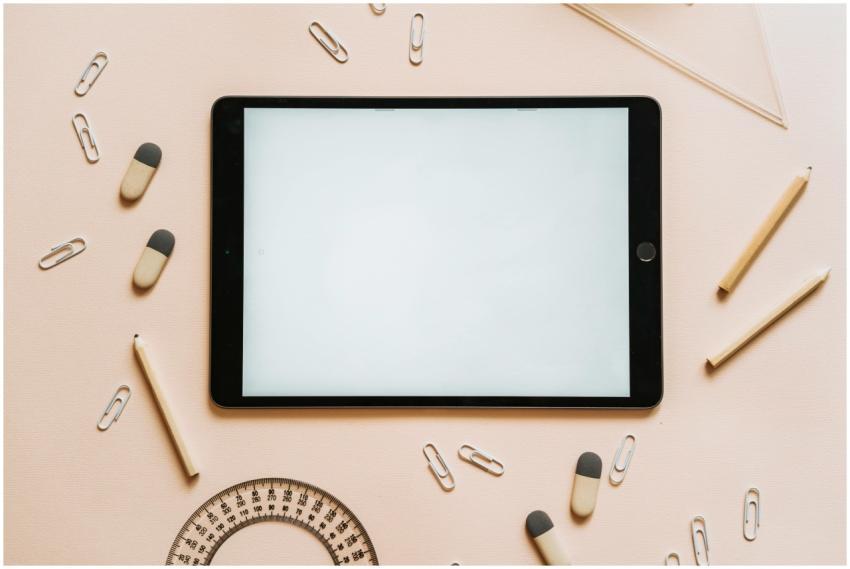 A tablet surrounded by stationery items like penci