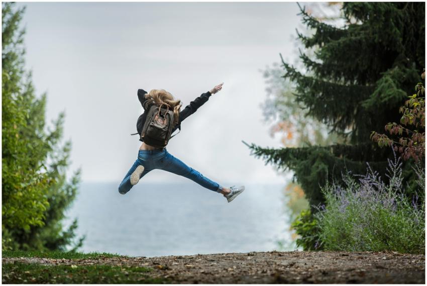 Energetic woman leaping in outdoor forest setting