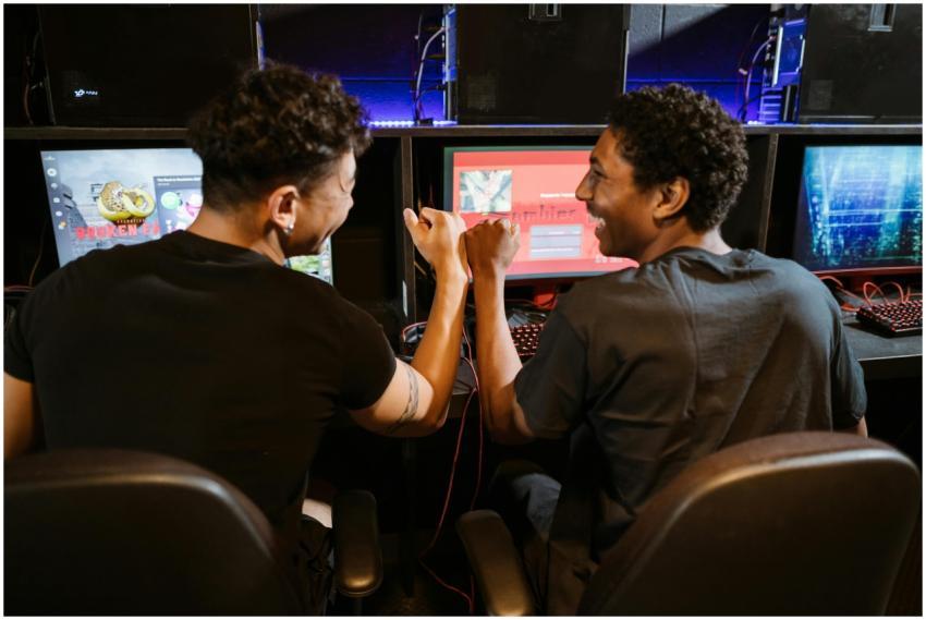 Two male friends enjoying a victory in a gaming co