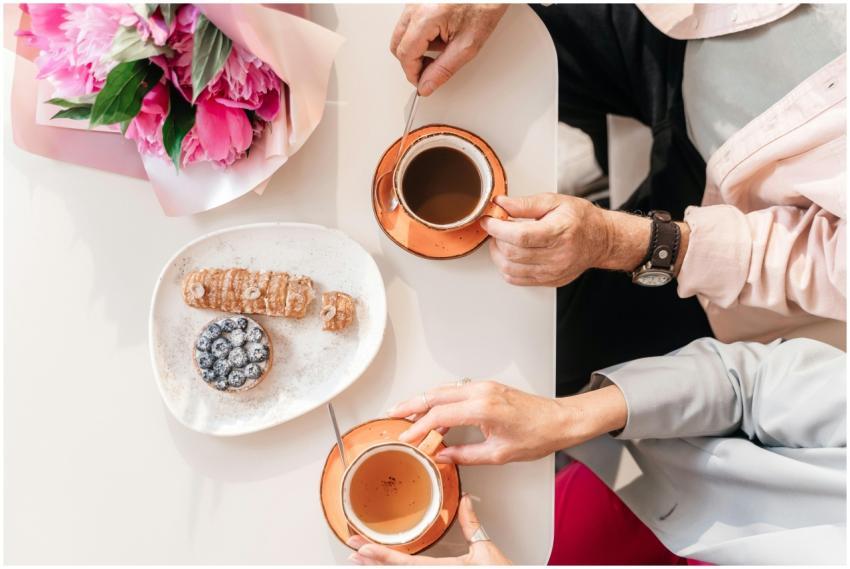 Top view of two people enjoying coffee and pastrie