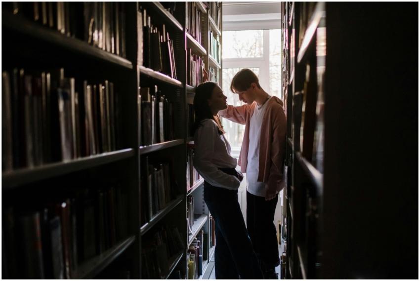 Two young adults having a discussion in a library