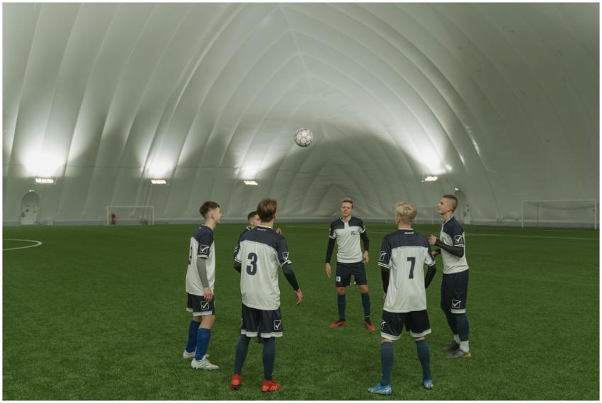 A soccer team practicing indoors, players in blue