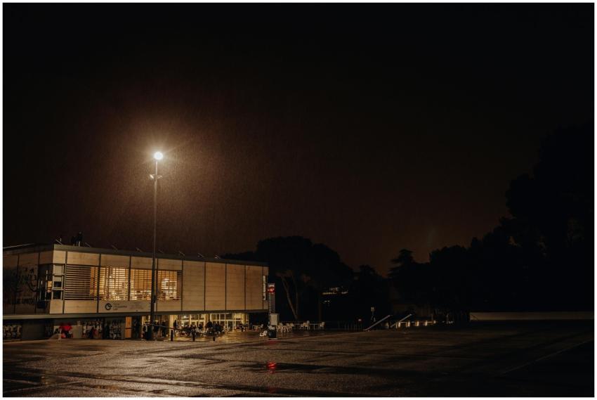 A nighttime urban scene featuring a modern buildin
