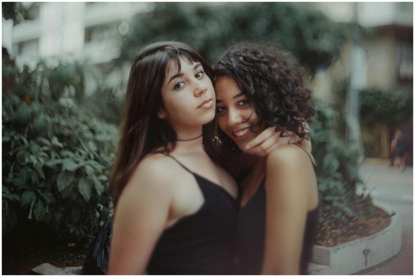 Two young women posing closely and smiling in an o