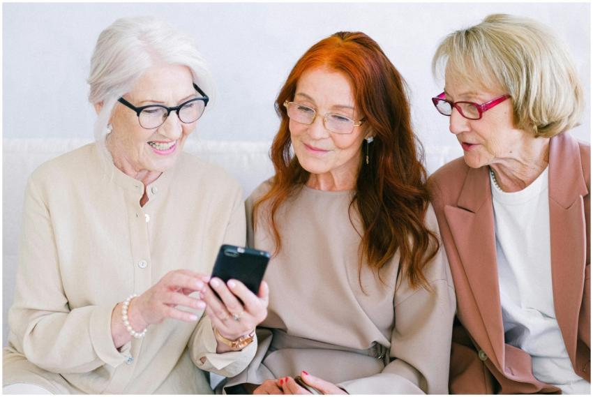 Three senior women enjoying a smartphone, sharing