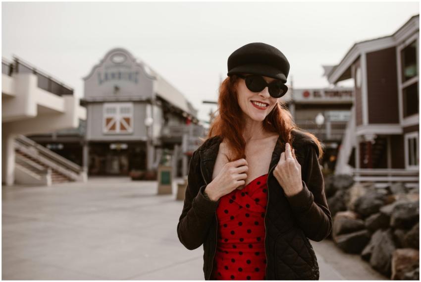 Stylish woman in red dress and black jacket smilin