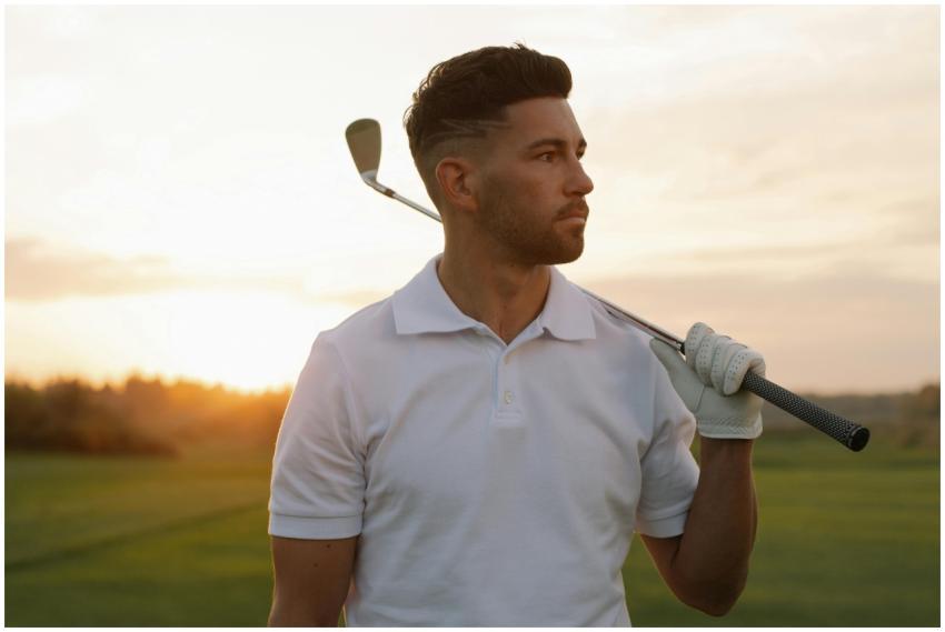 Portrait of a stylish male golfer posing with a cl