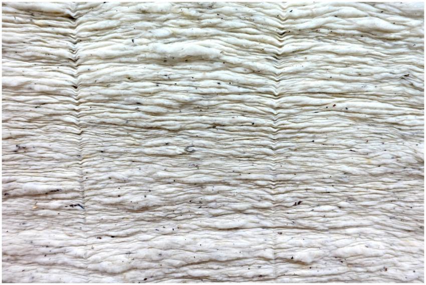 Close-up of a crumpled, uneven white fabric surfac