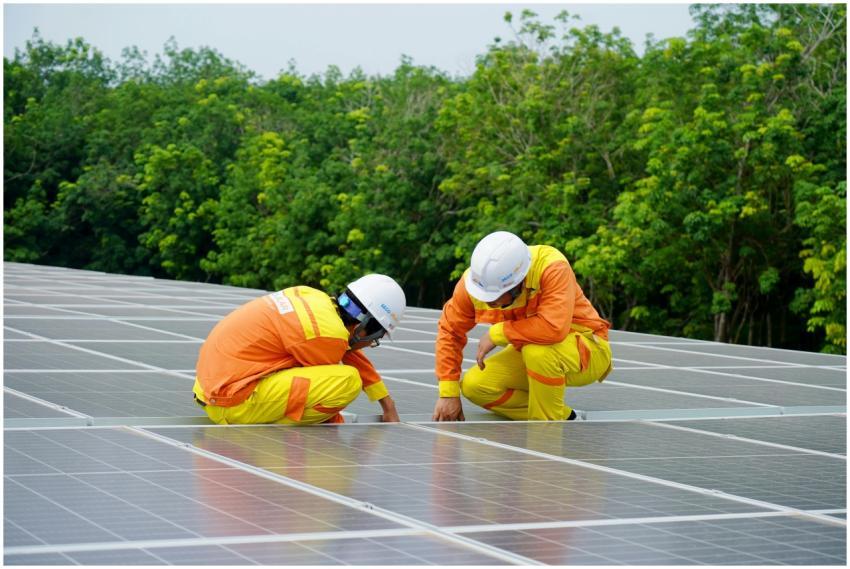 Workers installing photovoltaic solar panels on a