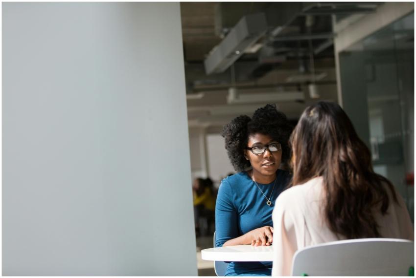 Two women engaged in a discussion in a modern offi